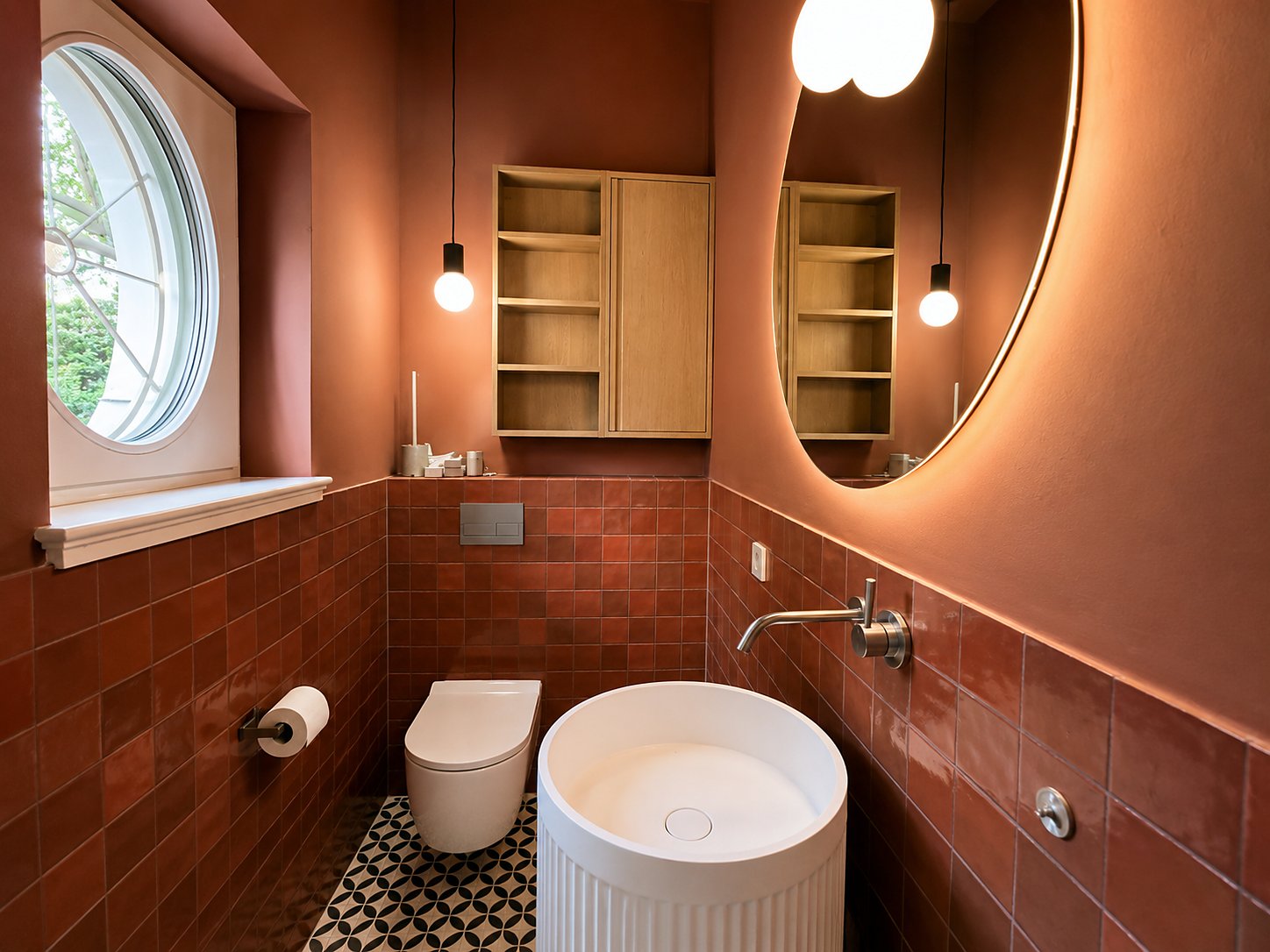 Gäste-WC mit roten Wandfliesen und gemustertem Boden